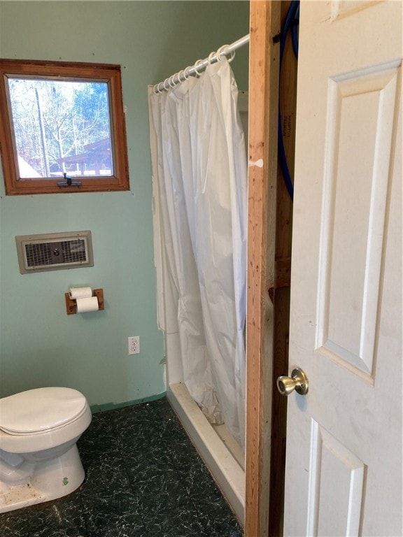 bathroom featuring a shower with curtain and toilet