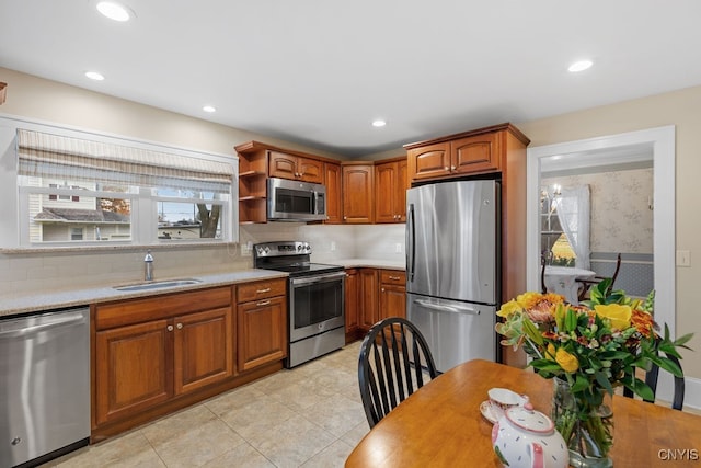 kitchen featuring light tile patterned floors, stainless steel appliances, decorative backsplash, and sink