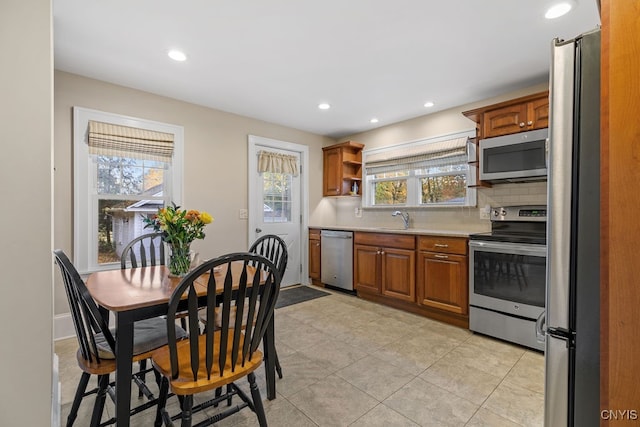 kitchen featuring tasteful backsplash, stainless steel appliances, sink, and light tile patterned floors