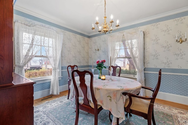 dining area with crown molding, a notable chandelier, a wealth of natural light, and hardwood / wood-style floors