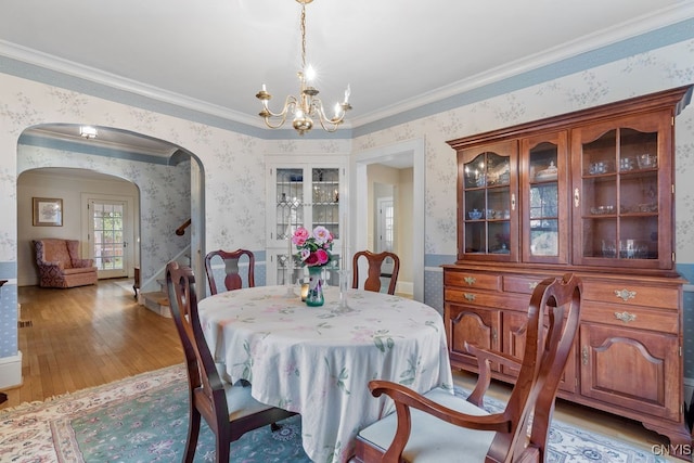 dining room with crown molding, a notable chandelier, and light wood-type flooring