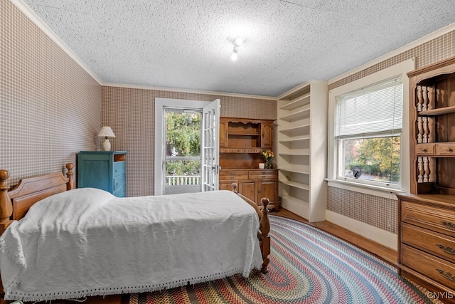 bedroom with crown molding, wood-type flooring, and a textured ceiling