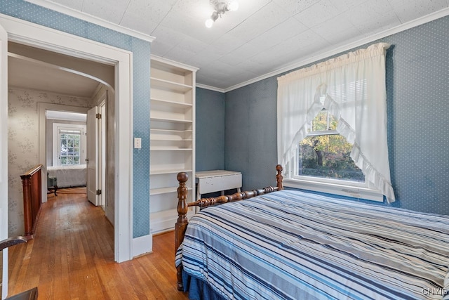 bedroom with crown molding and hardwood / wood-style flooring