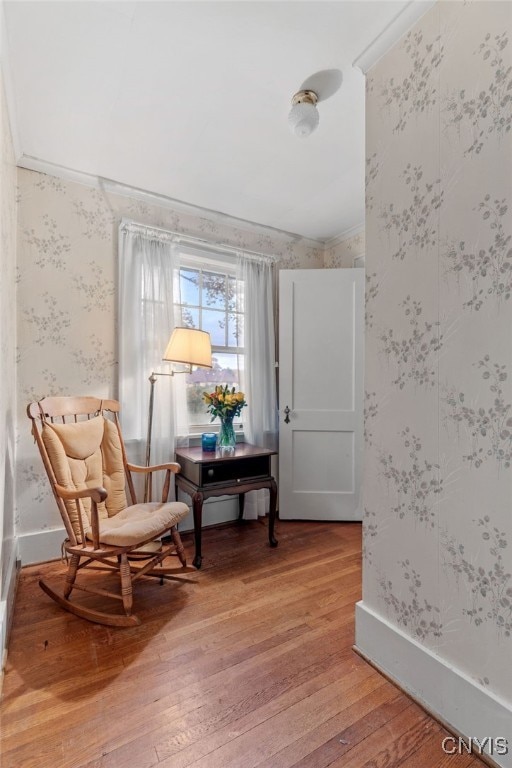 sitting room with crown molding and hardwood / wood-style flooring