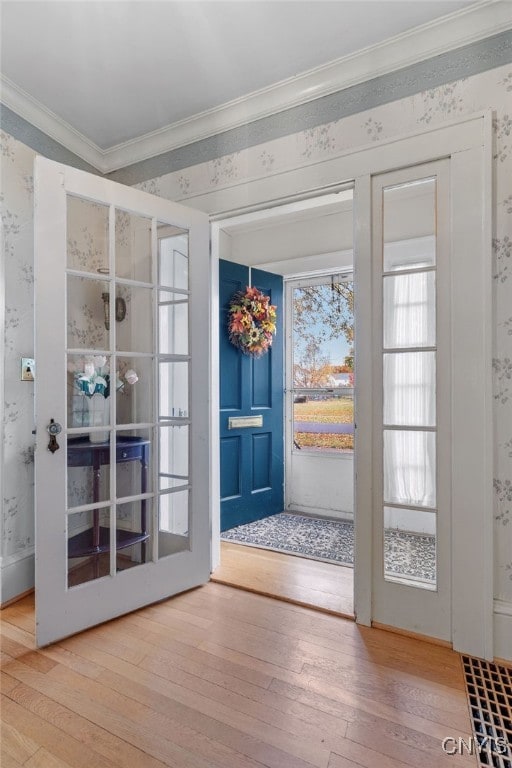 doorway featuring crown molding and hardwood / wood-style floors