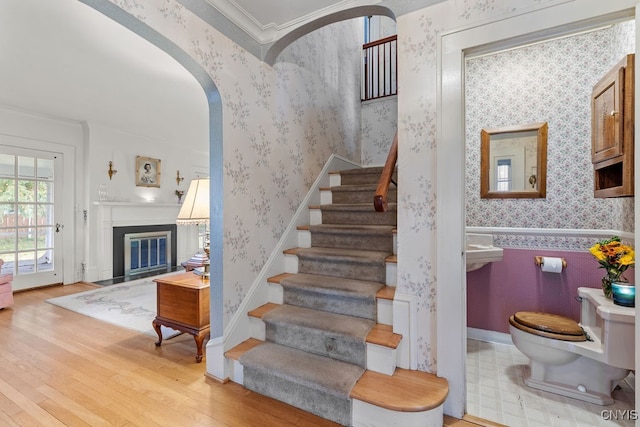 staircase featuring crown molding and wood-type flooring