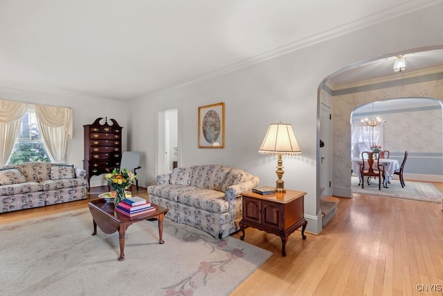 living room with crown molding, an inviting chandelier, and hardwood / wood-style floors