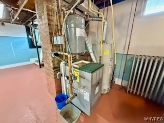 utility room featuring radiator heating unit and water heater