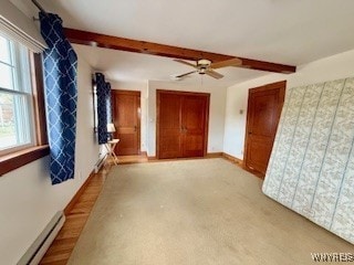 spare room featuring beam ceiling, baseboard heating, and a wealth of natural light