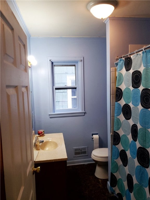 bathroom featuring toilet, ornamental molding, and vanity