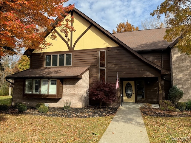 tudor-style house with a front lawn