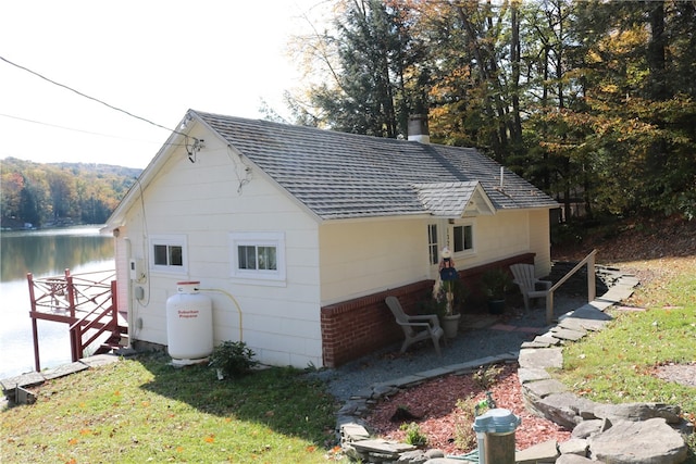 rear view of property with a lawn and a water view