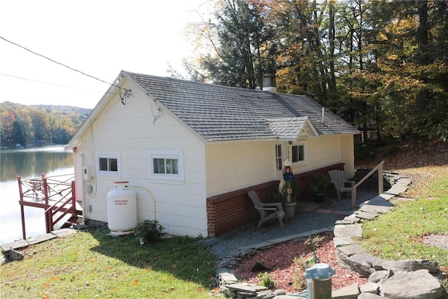 1323 Crystal Lake Rd, Deposit, NY 13783 - view of property exterior featuring a shingled roof, a yard, a water view, a chimney, and a patio area