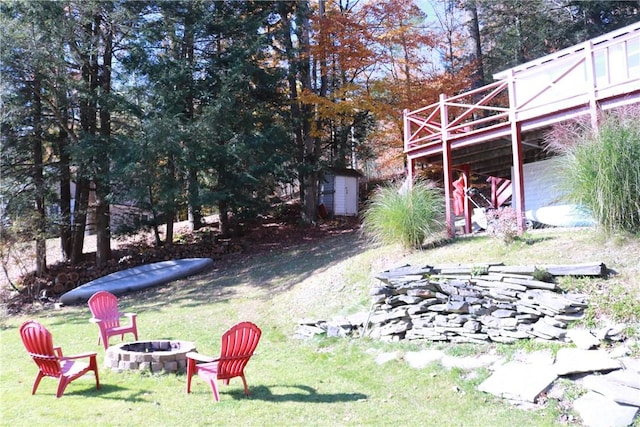 1323 Crystal Lake Rd, Deposit, NY 13783 - view of green lawn with an outdoor fire pit, a wooden deck, and a storage unit