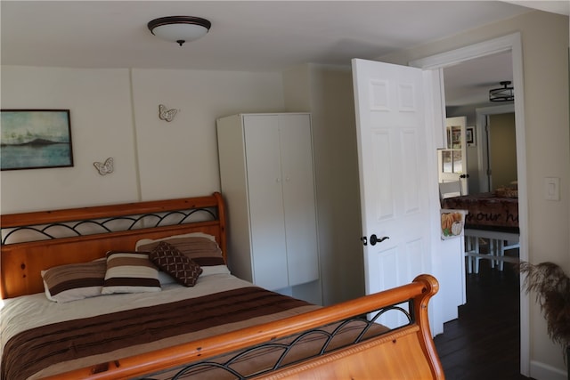 bedroom with dark hardwood / wood-style flooring