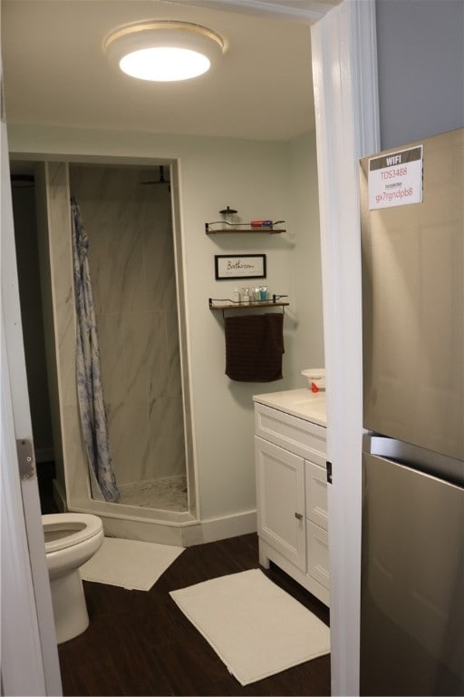 bathroom with vanity, toilet, hardwood / wood-style flooring, and curtained shower