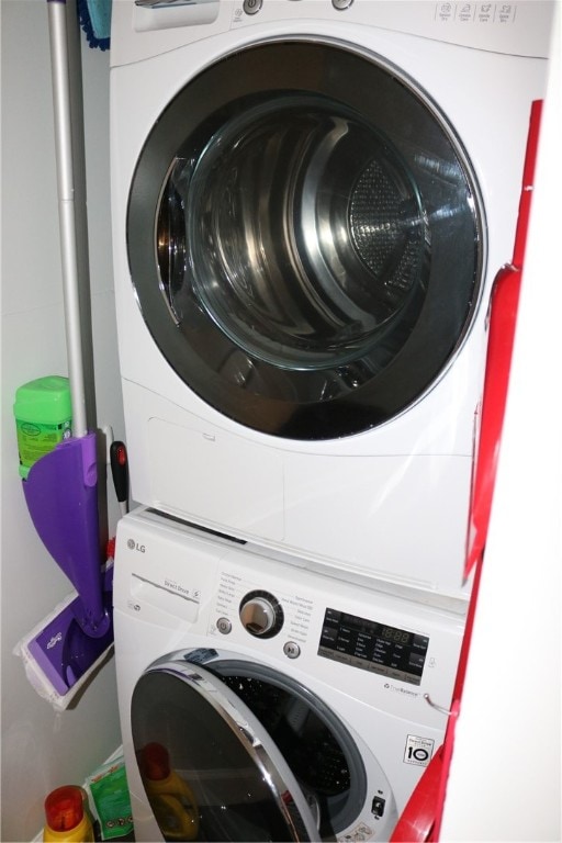 washroom with stacked washing maching and dryer