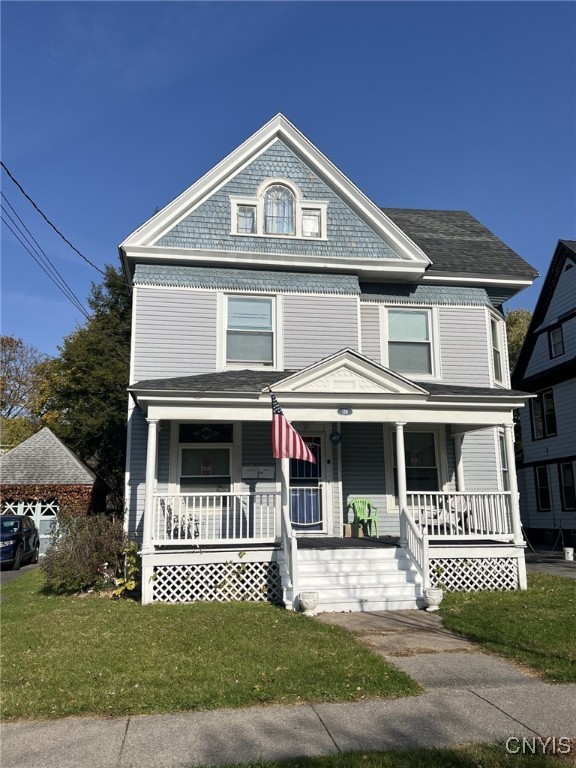 victorian house featuring a front yard and a porch