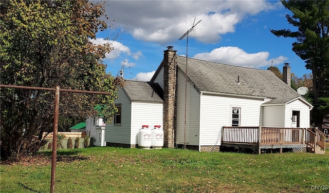 back of property featuring a wooden deck and a yard