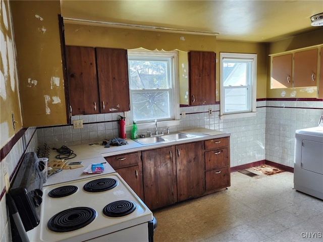 kitchen featuring washer / dryer, sink, electric stove, and plenty of natural light