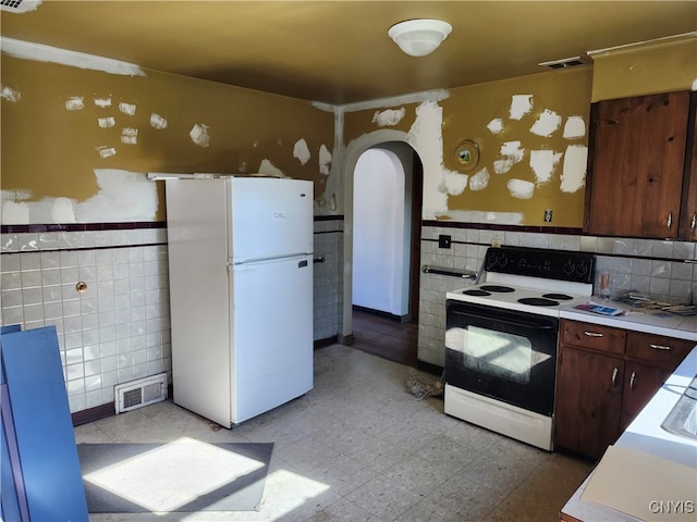 kitchen with white appliances and tile walls