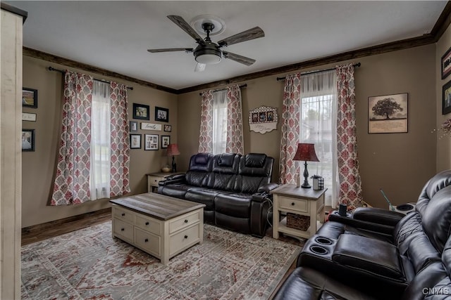 living area with ceiling fan, ornamental molding, and wood finished floors