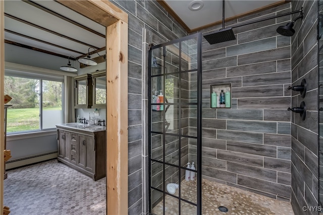 bathroom with vanity, a tile shower, and baseboard heating