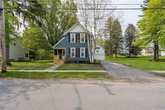 view of front of home with an outbuilding, a front yard, and a garage