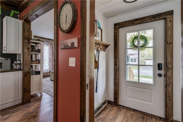 entryway featuring wood finished floors, a baseboard heating unit, and a wealth of natural light