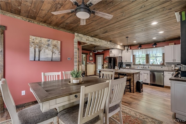 dining space featuring ceiling fan, wooden ceiling, sink, and light wood-type flooring