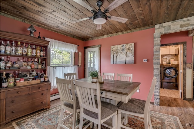 dining area featuring washer / dryer, baseboard heating, wooden ceiling, light hardwood / wood-style floors, and ceiling fan