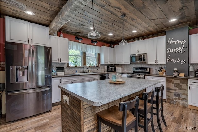 kitchen featuring a sink, light wood-style flooring, appliances with stainless steel finishes, and wooden ceiling