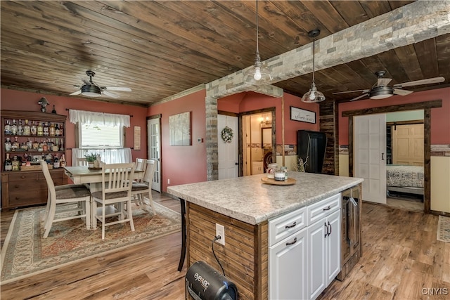 kitchen featuring light hardwood / wood-style flooring, white cabinetry, wooden ceiling, and hanging light fixtures