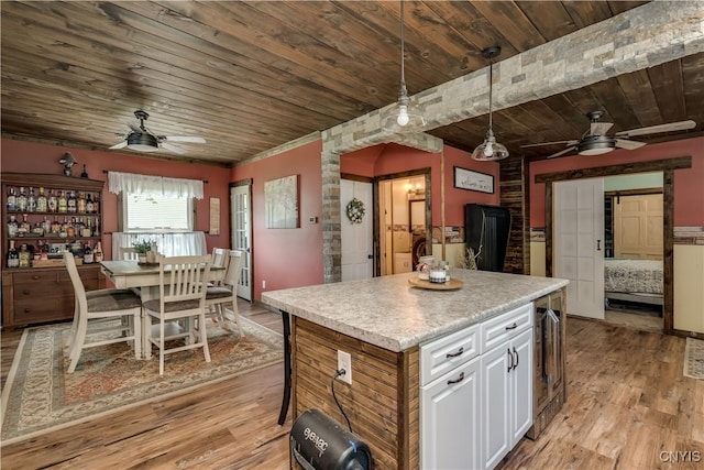 kitchen featuring beverage cooler, ceiling fan, wood ceiling, and light wood-type flooring