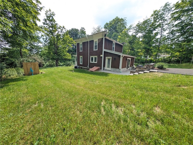 rear view of house with a patio and a lawn