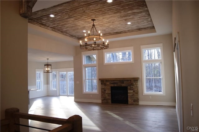 1015 Cold Springs Rd, Salina, NY 13088 - unfurnished living room featuring a stone fireplace, a healthy amount of sunlight, a chandelier, and dark wood-type flooring