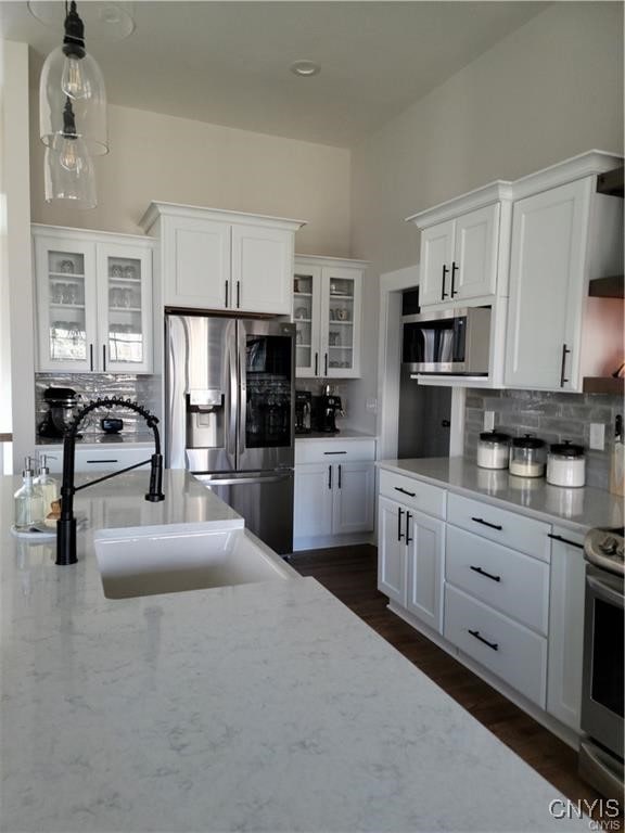 1015 Cold Springs Rd, Salina, NY 13088 - kitchen with appliances with stainless steel finishes, sink, backsplash, white cabinets, and dark wood-type flooring