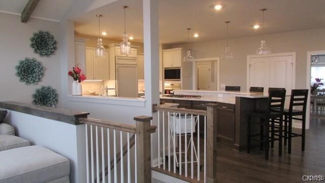 1015 Cold Springs Rd, Salina, NY 13088 - bar featuring beam ceiling, built in appliances, hanging light fixtures, white cabinets, and dark hardwood / wood-style flooring