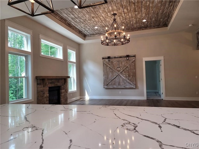 1015 Cold Springs Rd, Salina, NY 13088 - unfurnished living room with hardwood / wood-style flooring, a tray ceiling, a barn door, a notable chandelier, and a fireplace