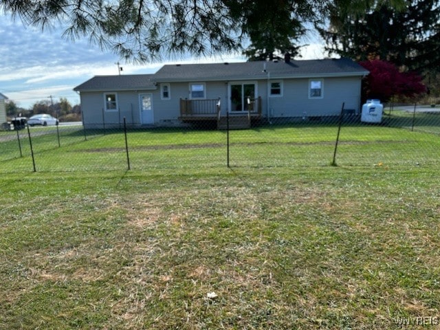 rear view of property with a yard and a deck