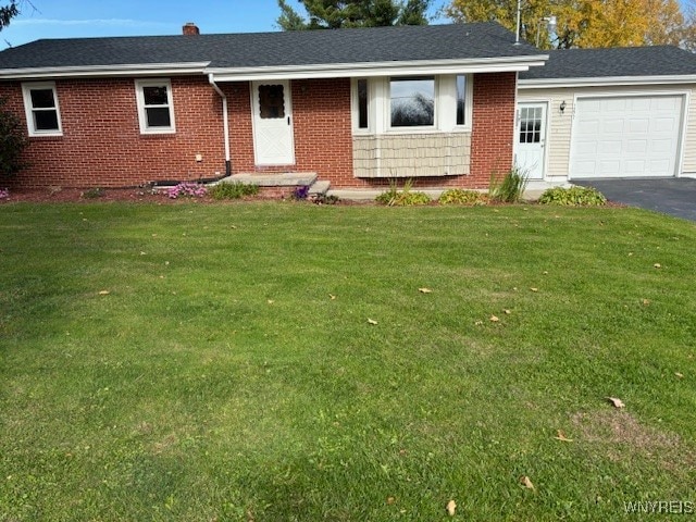 ranch-style home with a garage and a front lawn