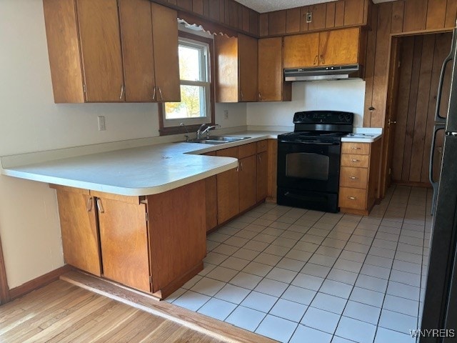 kitchen with black range with electric cooktop, sink, kitchen peninsula, and light tile patterned floors