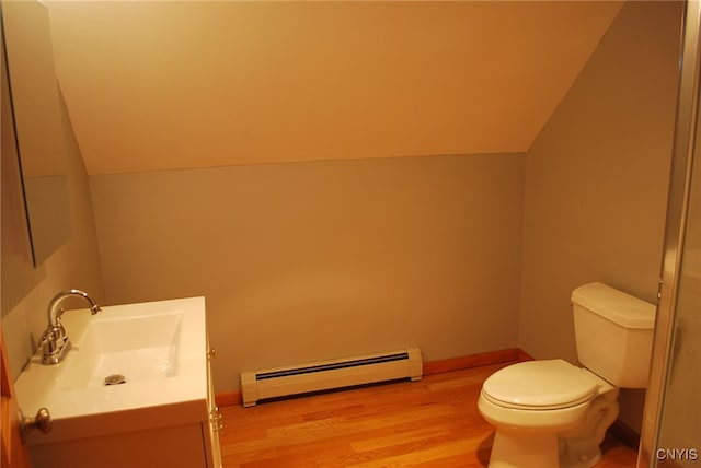 bathroom featuring toilet, vaulted ceiling, baseboard heating, vanity, and hardwood / wood-style flooring