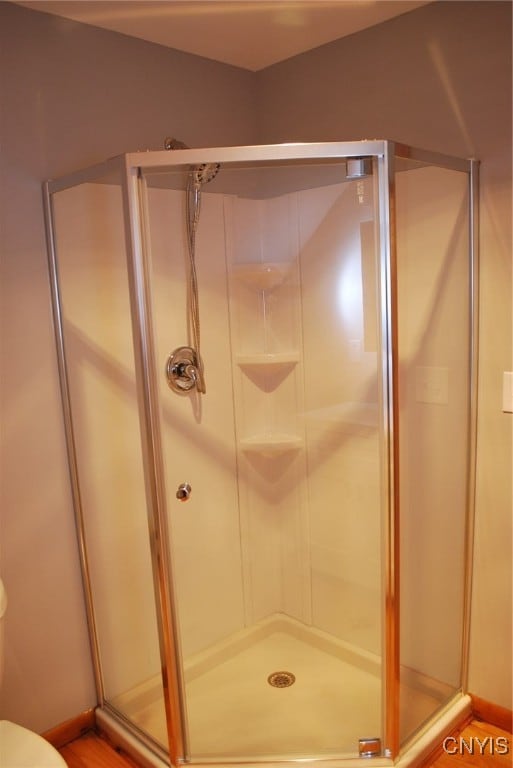 bathroom with toilet and an enclosed shower