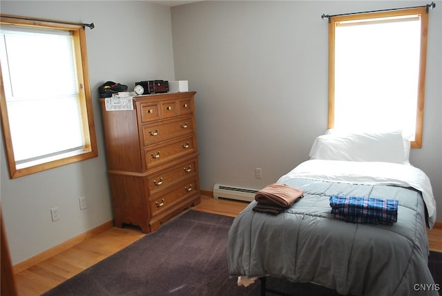 bedroom with hardwood / wood-style flooring and a baseboard radiator