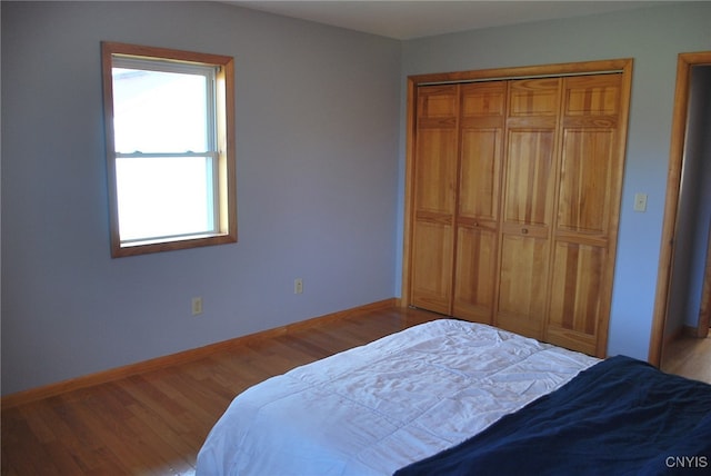 bedroom with light hardwood / wood-style floors and a closet