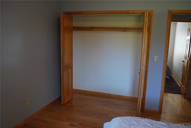 unfurnished bedroom with a closet and light hardwood / wood-style floors