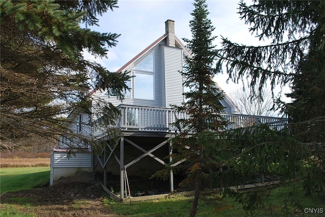 view of home's exterior with a deck and a lawn