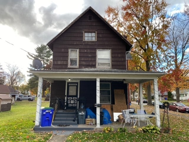 view of front of home with a porch and a front lawn