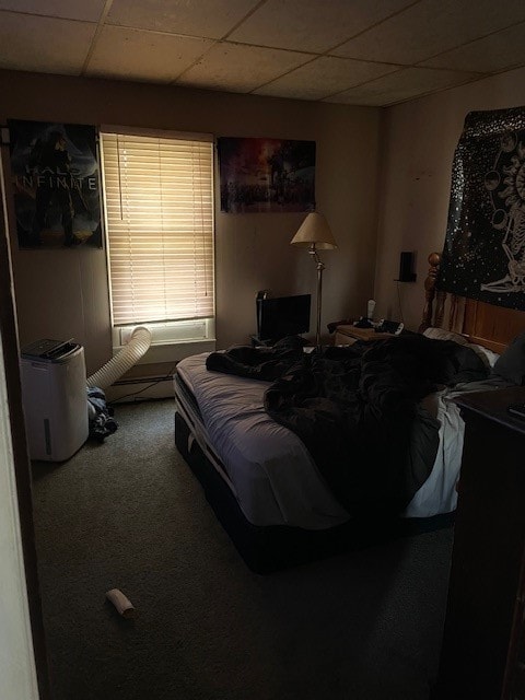 bedroom with a drop ceiling and carpet floors